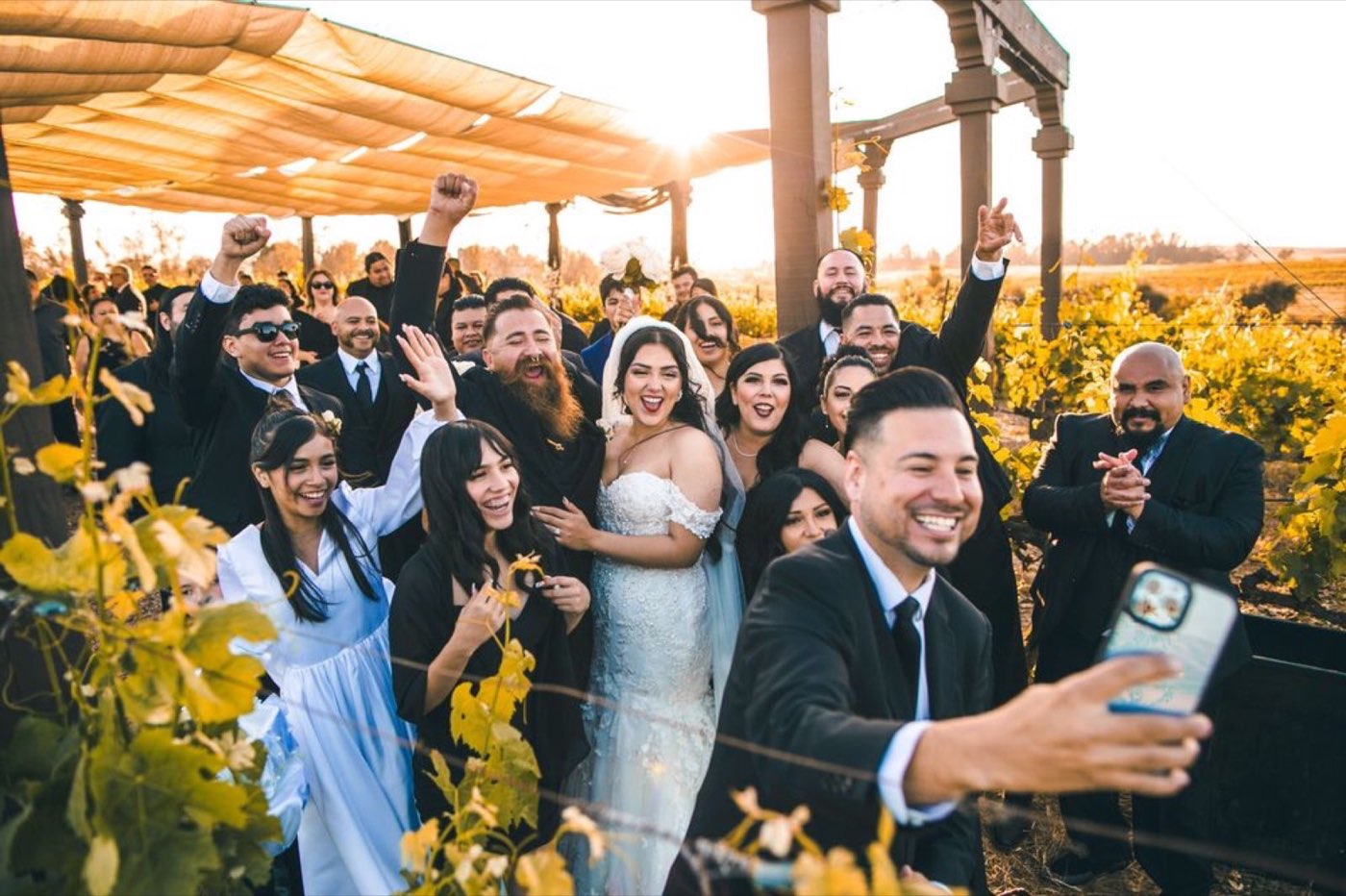 Mr. Mark taking a group selfie with a newly married couple and their guests