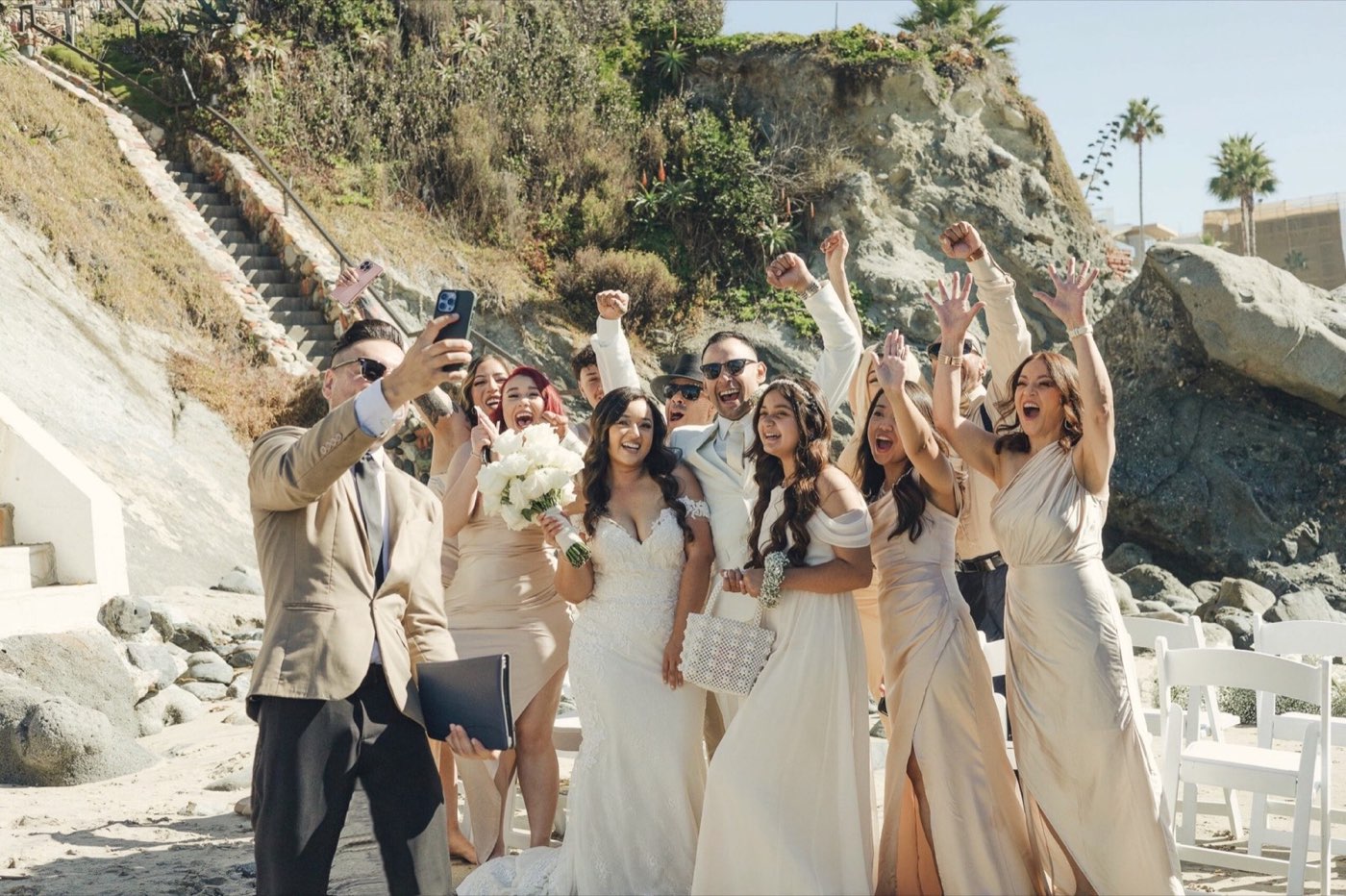 Mr. Mark taking a celebratory selfie with a wedding party at the beach